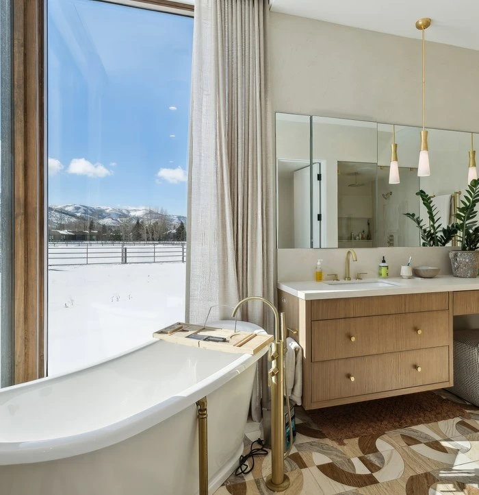 Primary bath with a freestanding tub and mountain views in a Park City home managed by Life Elevated