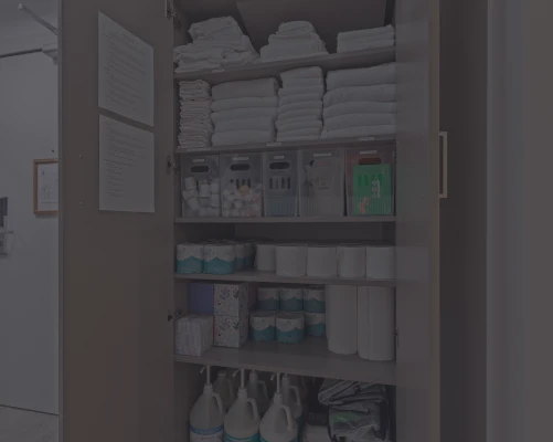 Supply closet stocked with fresh towels, paper goods and cleaning supplies at a managed rental